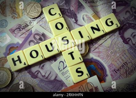 Housing costs - in words, Scrabble letters with England & Wales Sterling cash notes - Twenty Pounds, Ten Pounds, Five pound Stock Photo