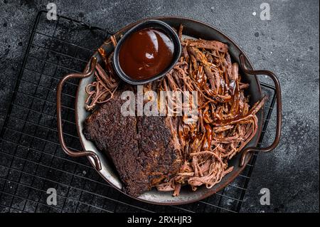 Slow Cooked Pulled Beef, Traditional meat rubbed with spices and smoked in a Texas smoker. Black background. Top view. Stock Photo