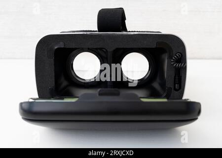 Virtual reality helmet on white background table. Black modern glasses for watching 360 degree videos for a smartphone. Stock Photo