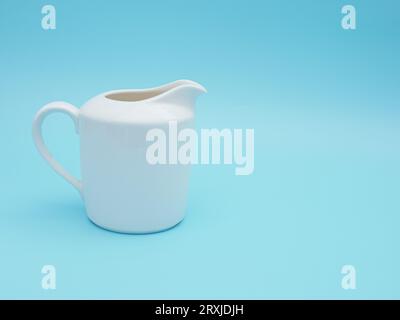 white milk pitcher isolated on blue background Stock Photo