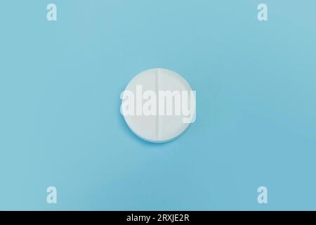 Medicine and drug concept. Close up shot of white pill on blue background. macro tablet Stock Photo