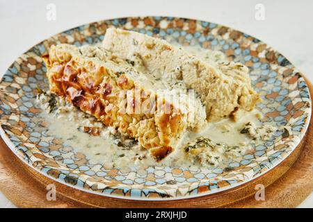 Chicken terrine with peppers, onions and herbs on plate Stock Photo