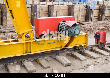 Large iron metal yellow supports on rails with wheels with an induction motor of a large construction stationary industrial powerful gantry crane of a Stock Photo