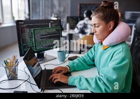Young developer concentrating on work with security codes on laptop at her workplace in office Stock Photo