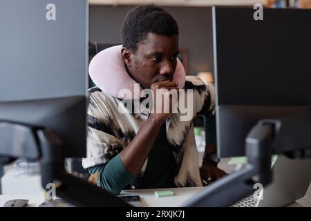 African American developer sitting at his workplace with computers in office Stock Photo