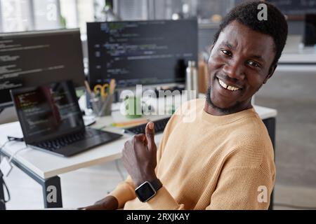 Portrait of African American successful programmer smiling at camera and showing thumb up Stock Photo