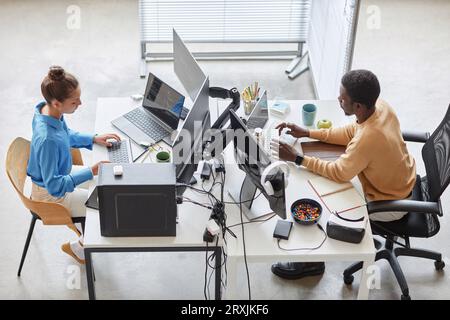 High angle view of couple of programmers typing codes on computers in IT office Stock Photo