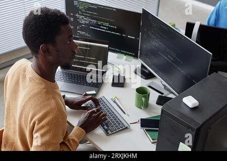 Serious African American developer working with security codes on computer at his workplace Stock Photo