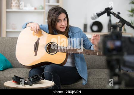 woman fillming how to restring a guitar for her blog Stock Photo