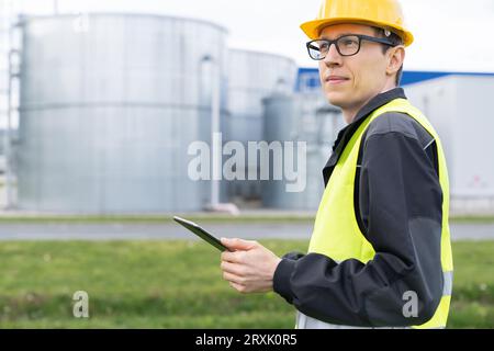 Engineer with digital tablet on a background of gas tanks. Stock Photo