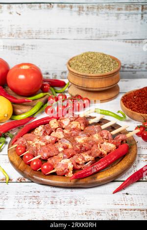 Lamb skewers on wood background. Raw lamb skewer with herbs and spices. Local name kuzu kusleme Stock Photo