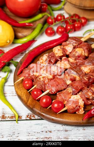 Lamb skewers on wood background. Raw lamb skewer with herbs and spices. Local name kuzu kusleme. Close up Stock Photo