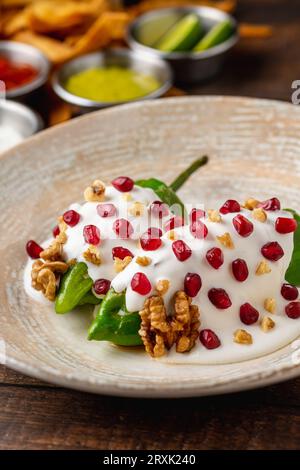 Chiles en Nogada, a traditional Mexican dish made with pablano chili stuffed with meat and fruit and garnished with pomegranate seeds and walnuts Stock Photo