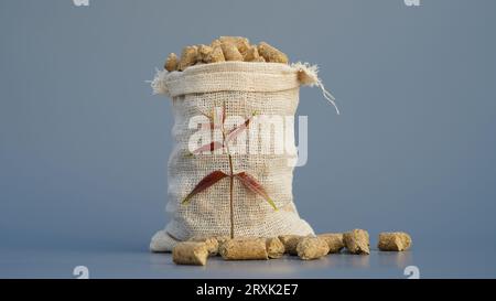 Burlap or jute bag of granulated chicken feed isolated on gray background. Closeup of poultry feed or pets healthy supplement in a bag on a studio bac Stock Photo