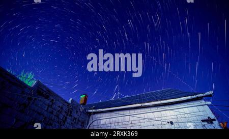 Star trails over old house Stock Photo