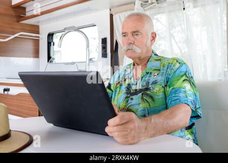 senior man using laptop in motorhome Stock Photo