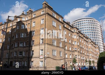 The brutalist façade of Harry Hyams' Space House on Kemble Street next to homes on the Peabody Trust Estate, London, WC2, England, U.K. Stock Photo