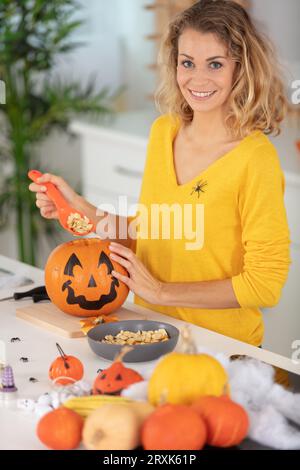 a woman prepares for halloween and carves pumpkins Stock Photo