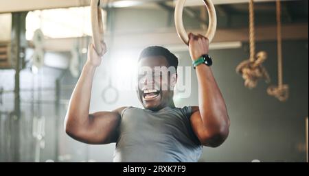 Gym, intense gymnastics and black man doing pull up exercise, arm muscle building or bodybuilding for strength training. Determined, athlete and Stock Photo