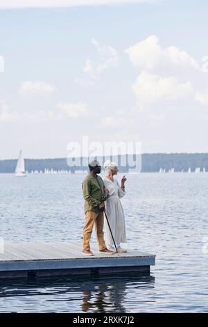 Vertical image of senior couple looking at the view of lake and enjoying the scenery Stock Photo