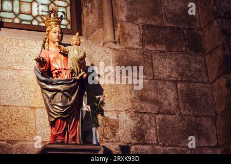 Ancient sculpture of the Virgin Mary with baby and angels. Vintage statue of Mother of God and Jesus Christ child. Faith and religion concept. Stock Photo