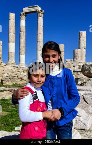 Cute local girls asked to pose for a photo at the Temple of Hercules, a 2nd Century Roman Temple in Amman, Jordan, Stock Photo