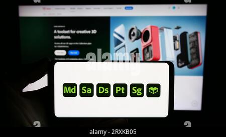 Person holding smartphone with logo of software product Adobe Substance 3D on screen in front of website. Focus on phone display. Stock Photo