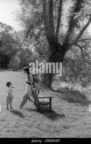A mother with her two children taking a riverside walk by the Windrush River near Minster Lovell in the Cotswolds in August 1990 Stock Photo