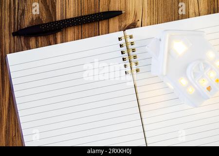 black pen next to open lined blank note pad mock up with ceramic home Stock Photo
