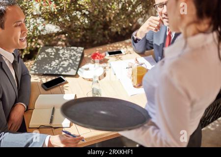 Businessmen in meeting at cafe Stock Photo
