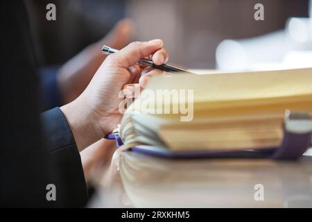 Hand of businessman holding pen Stock Photo