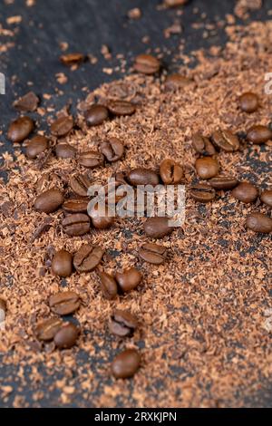 Roasted coffee beans lie together with chocolate crumbled into small pieces, fragrant coffee together with chocolate crumbs Stock Photo