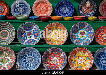 colourful brightly painted greek souvenir ceramics on display at a souvenir shop on zakynthos, brightly coloured greek ceramic pottery plates and dish. Stock Photo