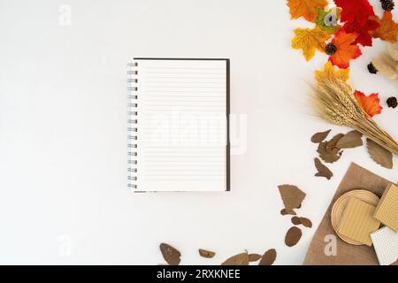 Workspace with blank copy space notebook mockup, blanket, envelopes, leaves on autumn background. Top view girl business, work concept top view Stock Photo