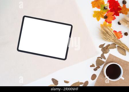 Workspace with blank copy space tablet mockup, notepad, blanket, envelopes, coffee cup, leaves on autumn background. work concept, cosy, cozy Stock Photo