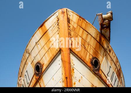bows or front of an old rusty corroded derelict fishing boat high and dry in the port of zante or zakynthos town. old fishing boat or shipwreck. Stock Photo