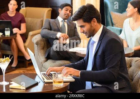 Businessman working on laptop at bar Stock Photo