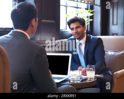 Businessmen in meeting at bar Stock Photo