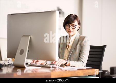 Businesswoman working on computer at desk Stock Photo