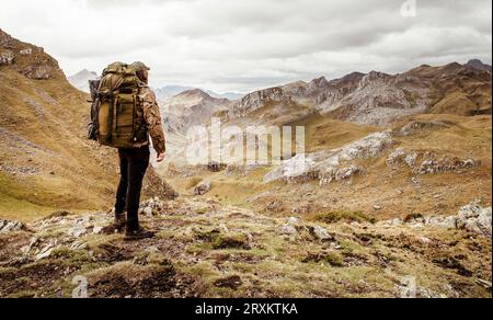 Man admiring view of valley during hike Stock Photo