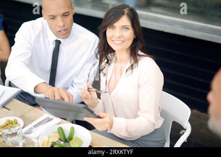 Businesspeople using tablet PC at restaurant meeting Stock Photo