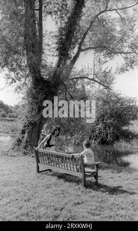 A mother with her two children taking a riverside walk by the Windrush River near Minster Lovell in the Cotswolds in August 1990 Stock Photo