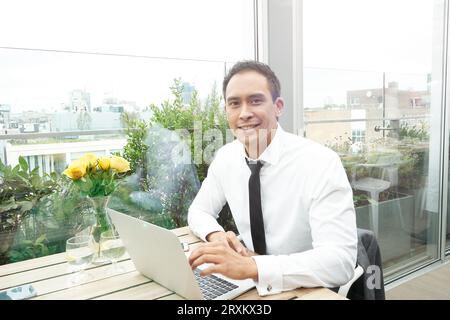 Businessman using laptop at restaurant table Stock Photo