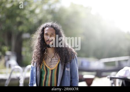Man with curly hair standing outdoors Stock Photo