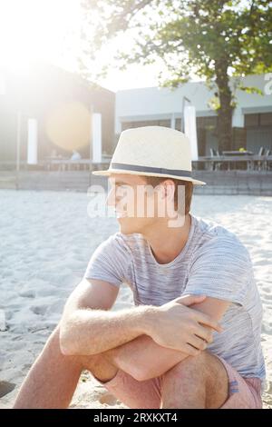 Young man wearing straw trilby hat on beach Stock Photo
