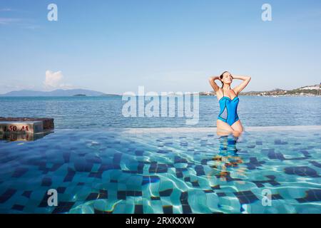 Young woman sitting poolside in Ko Samui, Thailand Stock Photo