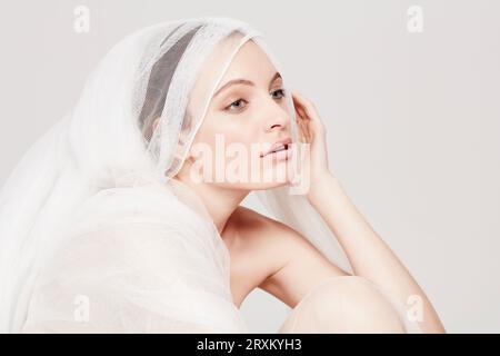 Young woman wrapped in sheer sheet Stock Photo