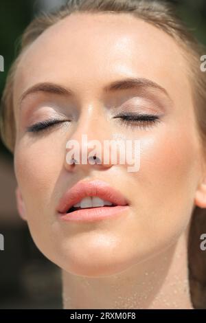 Headshot of young woman with her eyes closed Stock Photo