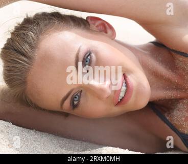 Woman lying on a sandy beach Stock Photo