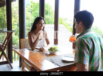 Young couple sitting at table with salad Stock Photo